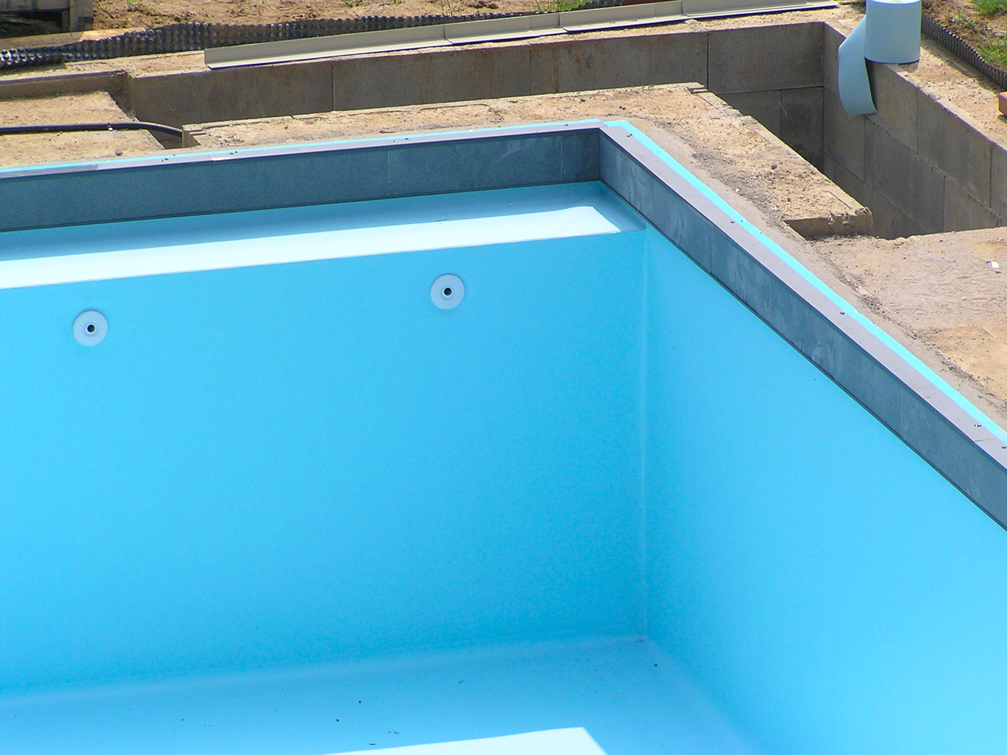 Pose des frises sur cette piscine extérieure 