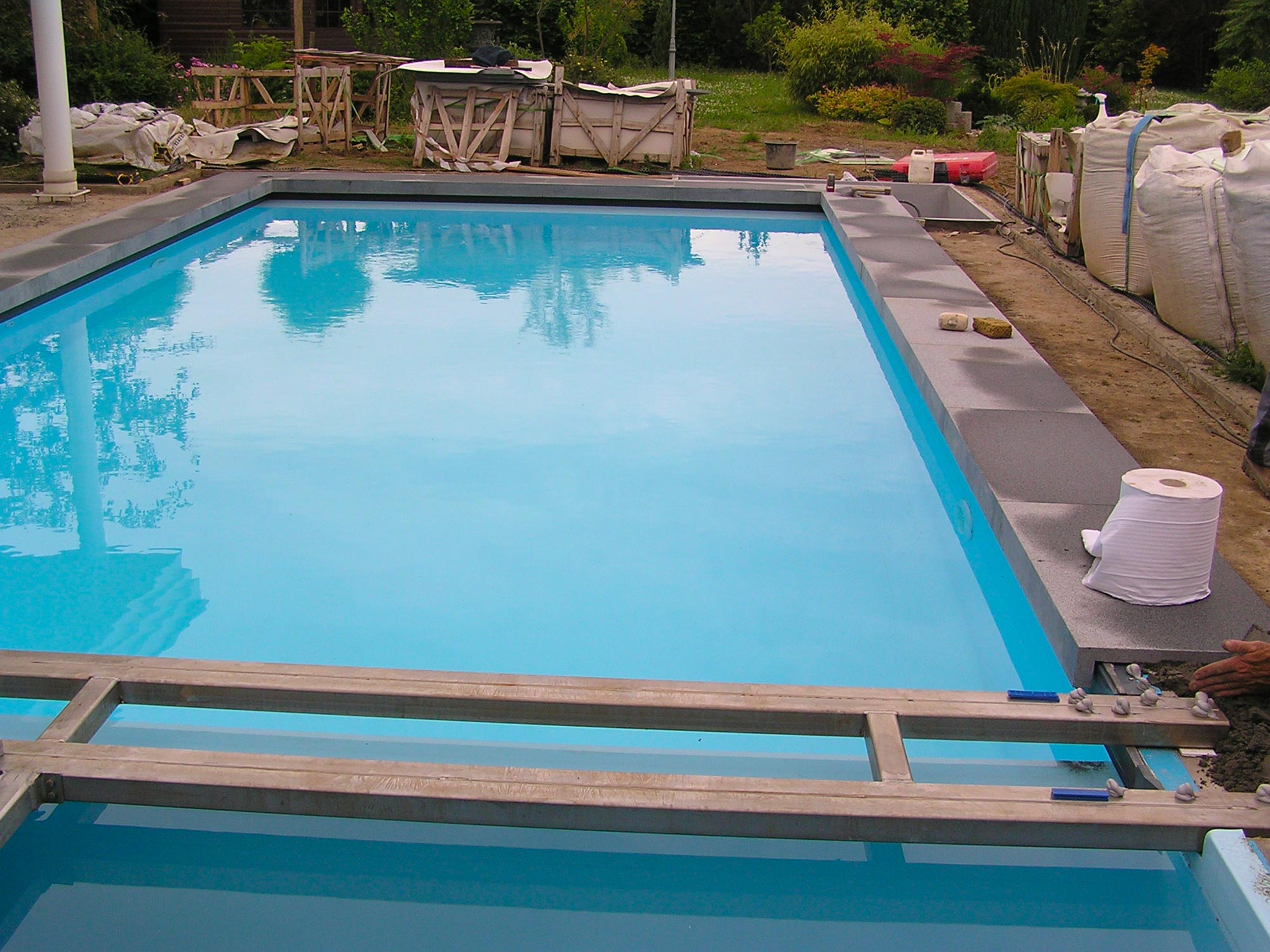 Pose de la margelle sur cette piscine extérieure rectangulaire